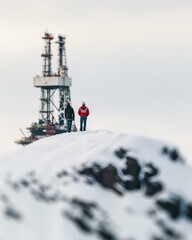 Canvas Print - Two people walk toward an oil rig in the distance. AI.