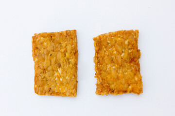 Tempeh Slices: A close-up view of fried tempeh slices, emphasizing the detailed texture and uniform golden color. The image captures the essence of this traditional Indonesian dish, making it ideal fo