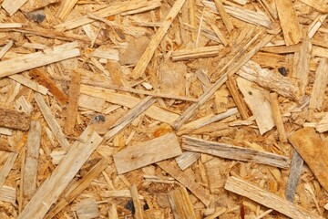 Wall Mural - Softly glowing wood fibers and wispy wood chips mingle on the rugged surface of weathered oriented strand board,
