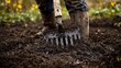 © Sasint - A close-up of a farmer using a broadfork to mix biochar into the topsoil, improving soil aeration and moisture retention