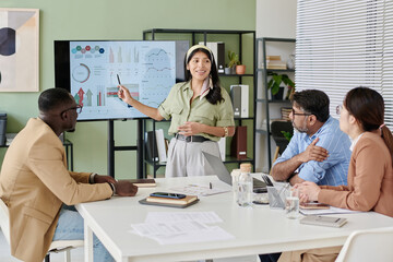 Aufkleber - Businesswoman presenting data on screen to diverse colleagues in modern office environment. Engaging in discussion while using presentation tools and charts