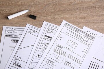 Leinwandbilder - Developing UI design. Sketches of website wireframes and felt pen on wooden table, top view