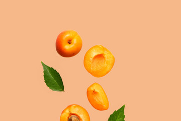 Flying fresh apricot with pieces and leaves on orange background