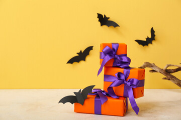 Wall Mural - Beautiful gift boxes and bats made of paper for Halloween on beige background