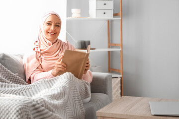 Sticker - Mature Muslim woman reading book at home