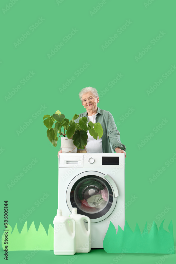 Happy senior woman with detergents doing laundry on green background