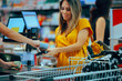 © nicoletaionescu - Woman Paying at the Supermarket Receiving Her Receipt. Happy customer making a money transaction at the cash register receiving the bill