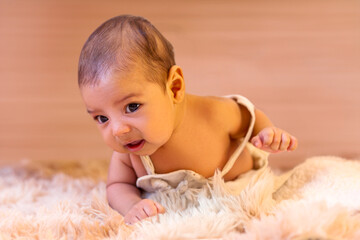 two-month-old baby boy lying face down on furry rug