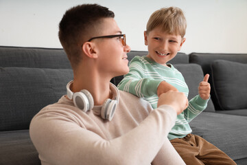 Canvas Print - Little boy with his working father bumping fists at home