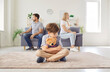 © Studio Romantic - Frustrated upset boy son sitting on floor with toy bear while his mother and father sitting on opposite sides of sofa ignoring each other after quarrel at home. Divorce and family conflicts concept.