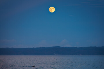 Wall Mural - This is a landscape of a yellow full moon rising over the sea on Thanksgiving Day in South Korea.