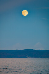 Wall Mural - This is a landscape of a yellow full moon rising over the sea on Thanksgiving Day in South Korea.