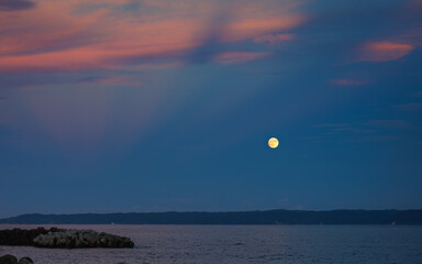 Wall Mural - This is a landscape of a yellow full moon and red sky floating over the sea on Thanksgiving Day in South Korea.