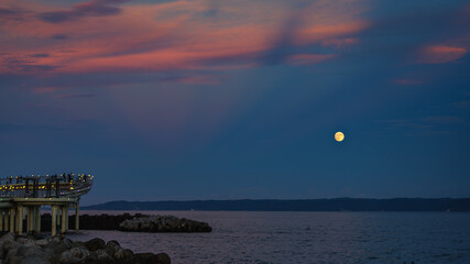 Wall Mural - This is a landscape of a yellow full moon and red sky floating over the sea on Thanksgiving Day in South Korea.