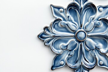 A close-up of a single, ornate blue majolica ceramic tile featuring a delicate floral design against a white background. The intricate details and glossy finish create a luxurious and elegant feel, pe