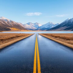 Open road leading towards distant mountains under a clear blue sky, serene wilderness scene