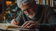 © Napasnan - Close-up of a grey-haired man writing in a journal, reflecting on his thoughts while sitting at a desk.