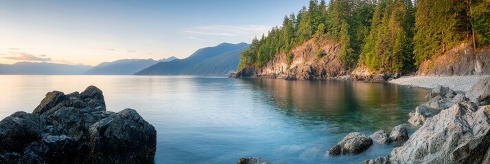 Wall Mural -  A large body of water enclosed by mountains and a forest lies before having rocks and trees on its opposite side