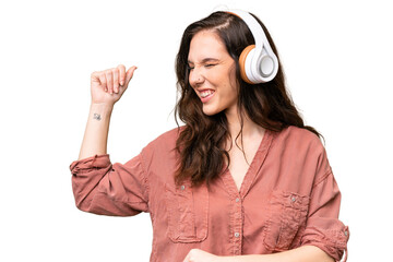 Wall Mural - Young caucasian woman over isolated background listening music and dancing