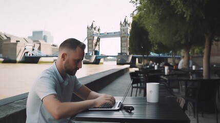 Man Working on Laptop at Outdoor Cafe in London with Tower Bridge View