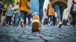 © Morng - Close-up of feet walking on a cobblestone street, capturing the urban hustle and diverse fashion in a bustling city environment.