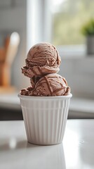 Two scoops of chocolate ice cream in a white bowl.