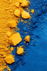 Sticker -  Next to one another on a blue-yellow surface, a mound of yellow powder and a pile of blue powder are positioned against a backdrop of solid blue