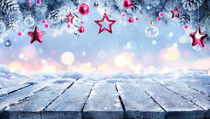 Wall Mural - christmas winter table with red ornament on snow - abstract snowfall in background