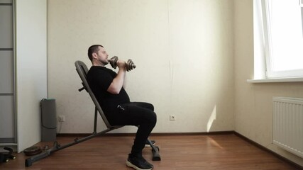 Wall Mural - Man exercising in home gym, working out with dumbbells to build muscles, maintaining a disciplined fitness routine.