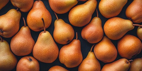 Poster - A vibrant collection of ripe pears lies scattered on a dark surface. The warm tones of the pears create a cozy atmosphere. Perfect for food photography and healthy living themes. AI