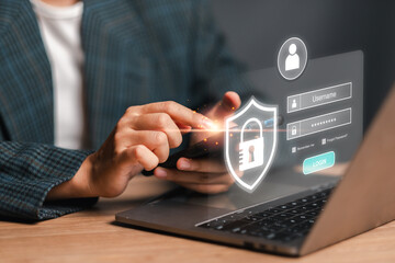 A modern login concept image featuring a hand interacting with a secure shield icon on a laptop screen, emphasizing user authentication and cybersecurity.