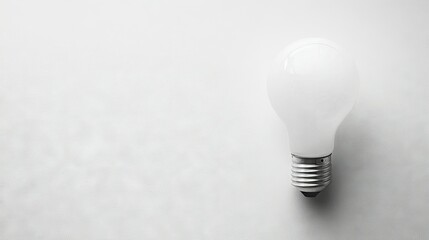 Poster - Flat lay of a light bulb with a clean, white surface, providing plenty of room for text or product placement on one side.