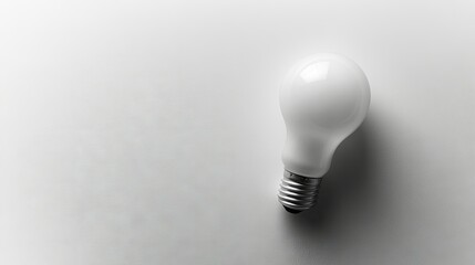 Poster - Flat lay of a light bulb with a clean, white surface, providing plenty of room for text or product placement on one side.