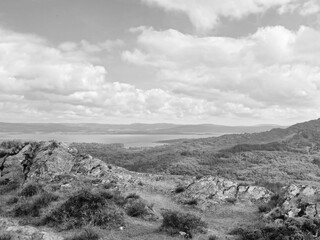 Green hills under blue summer sky landscape in Ireland, black and white monochrome grayscale photo