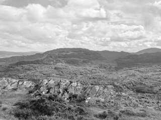 Green hills under blue summer sky landscape in Ireland, black and white monochrome grayscale photo