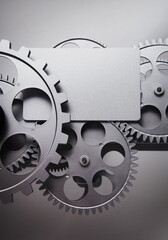 Wall Mural - card and gear wheel on a gray background.
