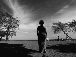 black and white silhouette of a person on a beach