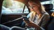 © Galib - A young woman with long brown hair is sitting in the back seat of a car, looking at her phone.