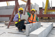 © Supachai - Asian male civil engineers wearing vest and helmet safety discussing foreman worker at construction site. Indian foreman with laptop working at factory making precast concrete wall.