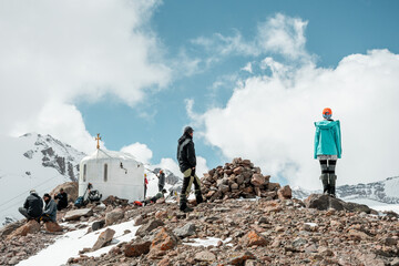 Kazbegi, Georgia - 18th september, 2024: Bethlehem Church and group of climbers stand on high viewpoint on acclimatization day. Climbing Mount kazbek preparation concept.