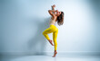 © chaossart - Young woman gymnast standing on wall background