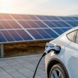 © Rossarin - Electric car charging with solar panels in the background, sustainable energy concept.