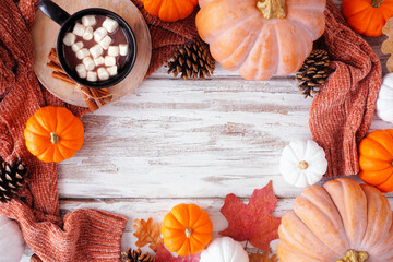 Poster - Cozy fall frame with pumpkins, sweaters and hot chocolate. Overhead view on a rustic white wood background.