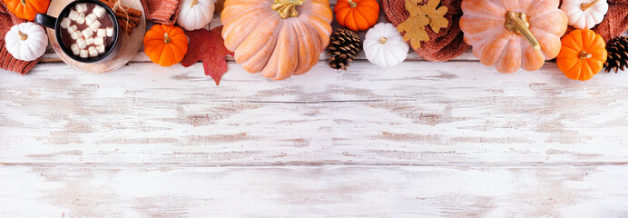 Poster - Cozy fall top border with pumpkins, sweaters and hot chocolate. Above view on a rustic white wood banner background.