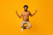 © Prostock-studio - Peaceful afro man meditating with zen gesture in air over orange studio background