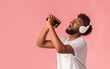 © Prostock-studio - Emotional african american man dancing, singing his favorite song on smartphone with closed eyes, using phone as microphone, pink studio background