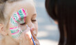 © Prostock-studio - Baby face painting. Woman artist painting face of kid outdoors, copy space