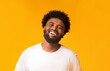 © Prostock-studio - Portrait of laughing afro man over orange background, life is good