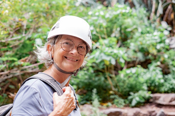 Sticker - Portrait of smiling senior hiker woman wearing protective helmets walking on mountain excursion enjoying freedom and nature. Freedom, success sport concept