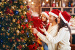 © Prostock-studio - Excited young family making Xmas tree together at home, getting ready before Christmas Eve, copy space